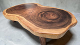 Handcrafted live edge Suar wood coffee table with solid hardwood legs at an angled front view.