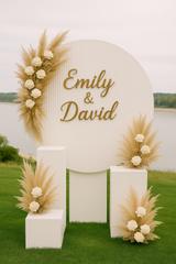 White ripple round backdrop with gold script 'Allison & Michael' sign, styled with dried florals and plinths on green garden lawn