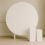 White ripple round backdrop sign, styled with dried florals and plinths on green garden lawn