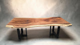 Solid Suar dining table featuring dramatic cathedral grain and natural live edge on black powder-coated steel legs