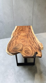 End view of live edge Suar dining table highlighting unique natural slab shape and character