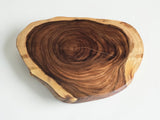 A rustic live-edge wooden serving board with natural tree growth patterns, shown on a clean white background.